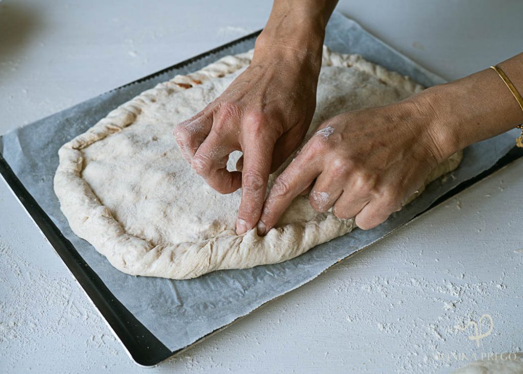 Haciendo los repulgues de la empanada gallega casera